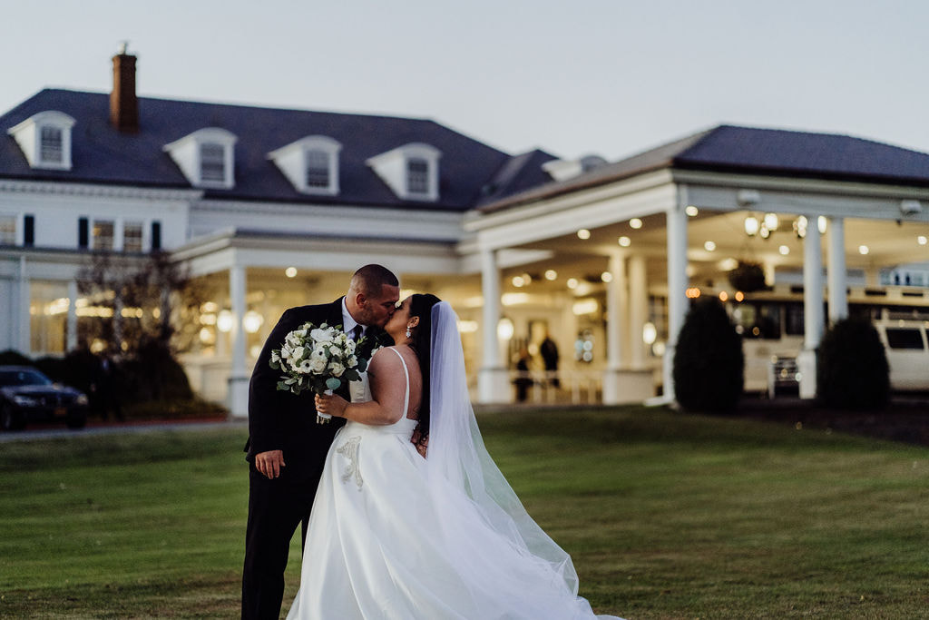 Country clubhouse outdoor wedding kiss