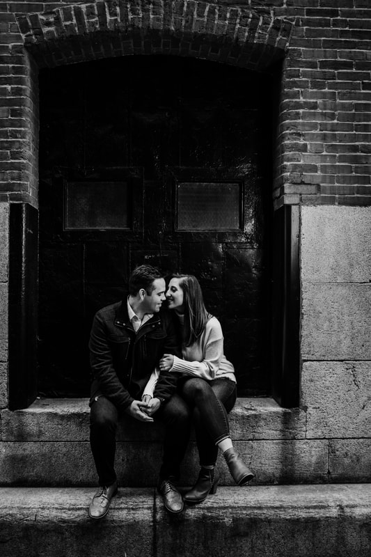 Black and white couple sitting in doorway of building