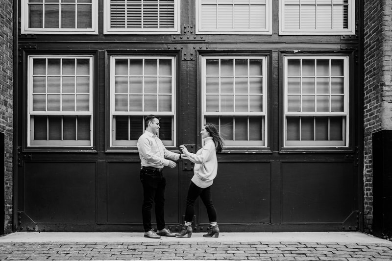 Black and white couple in motion against building