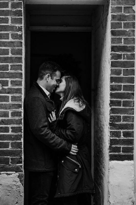 Black and white couple kissing in building doorway