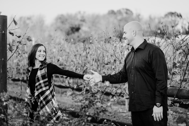 Black and white couple holding hands in vineyard