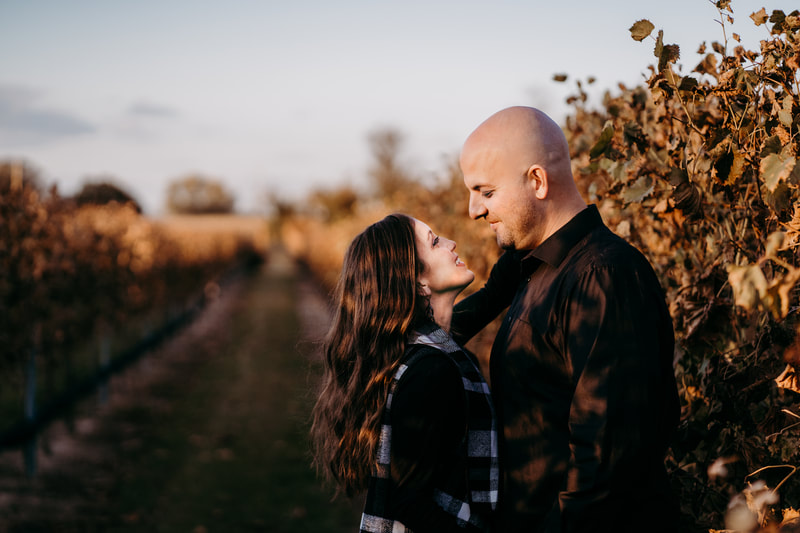 Couple at sunset looking at each other in vineyard