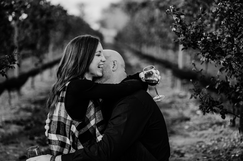 black and white Couple in vineyard drinking wine